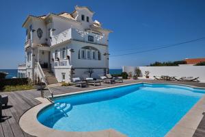 a villa with a swimming pool in front of a house at Casal Santa Virginia in Sintra
