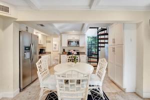 a kitchen with a white table and chairs in a room at The Blue Pearl - Soak Up Views from a Scenic Poolside Upper Deck in West Palm Beach