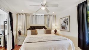 a bedroom with a bed with a ceiling fan at The Blue Pearl - Soak Up Views from a Scenic Poolside Upper Deck in West Palm Beach +13 photos