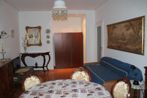 a living room with a blue couch and a table at Coroneo33 - Spazioso per famiglie - NaonBnB in Trieste