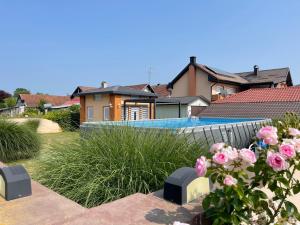 a house with a swimming pool and pink roses at Sobe Obitelji Glavaš in Garešnica