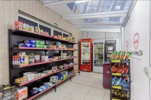 a grocery store aisle with a red refrigerator and shelves at Loft estiloso no centro, perto de tudo!!!! in Curitiba