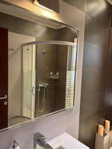 ein Badezimmer mit Spiegel und Waschbecken in der Unterkunft Apartman Centar VV in Kragujevac + 15 Fotos