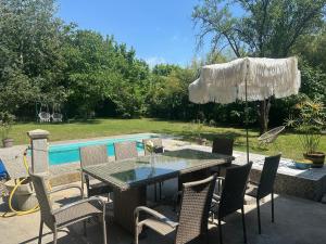 a patio with a table and chairs and a pool at Prenoćiste Casa Bella & Nova in Palić