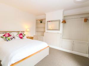 a bedroom with a white bed and a tv at Highland House in Sheringham