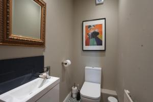 a bathroom with a toilet and a mirror and a sink at Four bedroom detached family home near Elie in Kilconquhar +36 photos