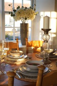 a table with plates and glasses and a vase with flowers at Four bedroom detached family home near Elie in Kilconquhar
