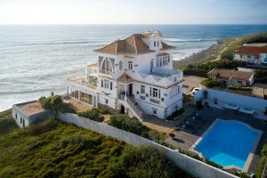 an aerial view of a large white house on the ocean at Casal Santa Virginia in Sintra