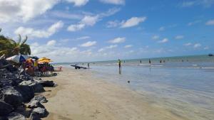 a group of people on a beach with the ocean at Residencial João Feitosa in Paulista