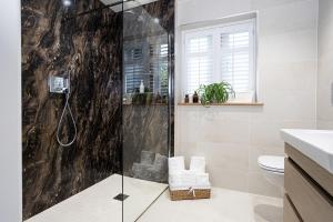 a bathroom with a shower with a glass door at Hen Harrier Lodge in Lancaster +32 photos