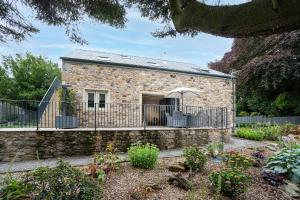 a stone house with a fence in front of it at Hen Harrier Lodge in Lancaster