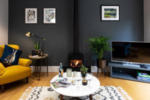 a living room with a yellow couch and a coffee table at Hen Harrier Lodge in Lancaster