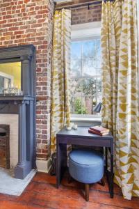 a table in a room with a window and a chair at Sunny Queen Suite Downtown 2nd Floor in Savannah