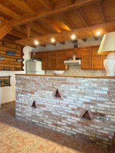 a kitchen with a brick wall and wooden cabinets at Traditional House in Pámfylla