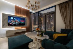 a living room with a blue couch and a tv at Stylish 2BR with Boulevard View & 5 min from Dubai Mall in Dubai