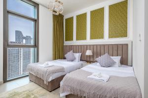 two beds in a hotel room with a window at Stylish 2BR with Boulevard View & 5 min from Dubai Mall in Dubai +25 photos