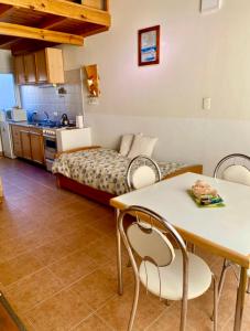 Una sala de estar con una cama, una mesa y sillas. en Esquel Apart Loft, en Esquel 4 fotos más
