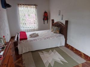 a bedroom with a bed and a window at Camping Serra São José in Tiradentes