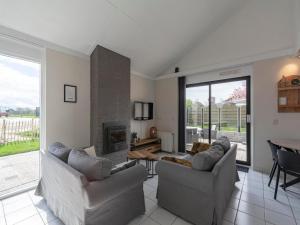 ein Wohnzimmer mit zwei Sofas und einem Kamin in der Unterkunft Holiday Home in Julianadorp by Beach in Julianadorp
