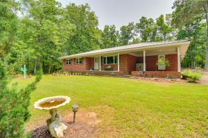 a small brick house with a mushroom in the yard at 13 Mi to Guntersville Lake Henagar Gem with Hot Tub in Pisgah