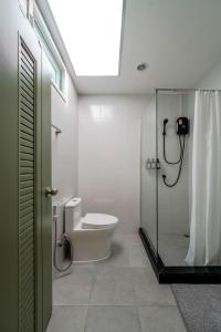 a bathroom with a toilet and a glass shower stall at Blue House 191 Hometel in Chinatown +34 photos