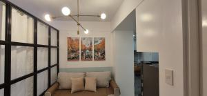 a living room with a couch and a painting on the wall at CozyNest Rentals at Brenthill Condominium in Baguio