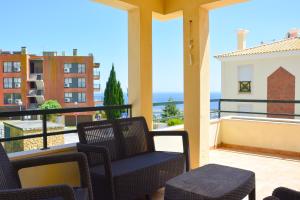 a balcony with chairs and a view of the ocean at Villa Terraços do Castelo by DolceStay in Sesimbra