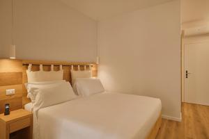 a bedroom with a large white bed with white pillows at Hotel Le Mura in Lazise