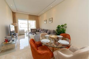 a living room with a glass table and chairs at Welcome Sidi Rehal Escape 3Beds Sea & Vue Piscine in Sidi Rahal