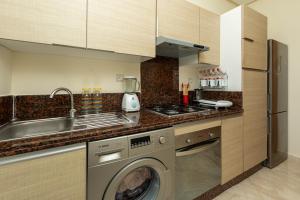 a kitchen with a washing machine and a sink at Welcome Sidi Rehal Escape 3Beds Sea & Vue Piscine in Sidi Rahal
