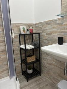 a bathroom with a black shelf next to a sink at Mamma Chica Alloggio Turistico a Palermo in Palermo