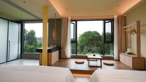 ein Schlafzimmer mit einem Bett und einem großen Fenster in der Unterkunft 张家界溪畔民宿-Zhangjiajie The Brookside Hotel in Zhangjiajie + 69 Fotos