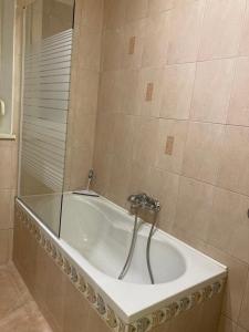 a bath tub with a faucet in a bathroom at Nice apartment in Celje in Celje