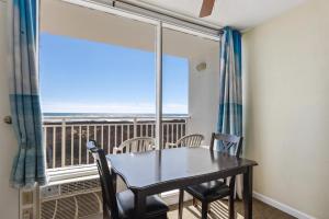 Un comedor con mesa y sillas y un balcón. en 6201 Ocean Ave, Unit 314 - The Nassau Inn, en Wildwood