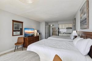 Una habitación de hotel con dos camas y un escritorio. en 6201 Ocean Ave, Unit 311 - The Nassau Inn, en Wildwood