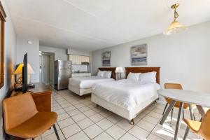 Un dormitorio con dos camas y una mesa y una cocina. en 6201 Ocean Ave, Unit 311 - The Nassau Inn, en Wildwood