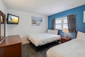 Una habitación de hotel con dos camas y una ventana. en 6201 Ocean Ave, Unit 409 - The Nassau Inn, en Wildwood