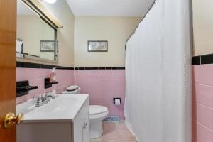 a pink and white bathroom with a sink and a toilet at 219 W Chestnut Ave in North Wildwood +24 photos
