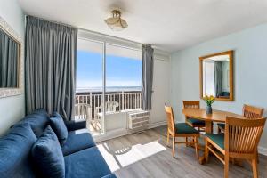 sala de estar con sofá azul y mesa de comedor en 6201 Ocean Ave, Unit 312 - The Nassau Inn, en Wildwood