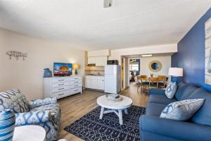 Una sala de estar con un sofá azul y una mesa. en 6201 Ocean Ave, Unit 402 - The Nassau Inn, en Wildwood
