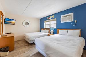 Una habitación de hotel con dos camas y una pared azul. en 6201 Ocean Ave, Unit 402 - The Nassau Inn, en Wildwood 18 fotos más