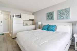 Un dormitorio con una gran cama blanca con almohadas azules. en 6201 Ocean Ave, Unit 412 - The Nassau Inn, en Wildwood