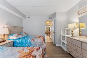a bedroom with two beds and a dresser and a mirror at 3110 Atlantic Ave, Unit 304 in Wildwood +31 photos