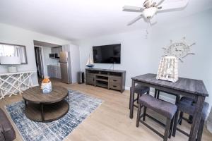 Una sala de estar con una mesa y un televisor. en 6201 Ocean Ave, Unit 210 - The Nassau Inn, en Wildwood