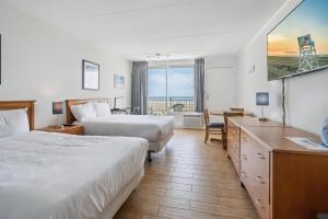 Una habitación de hotel con dos camas y un escritorio. en 6201 Ocean Ave, Unit 511 - The Nassau Inn, en Wildwood