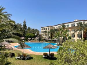 a view of a pool with chairs and umbrellas at Marina Palace in Hammamet