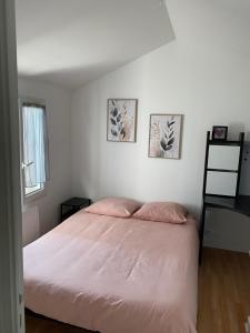 1 dormitorio con 1 cama y 3 cuadros en la pared en Maison proche de l'aéroport et Nantes, en Rezé