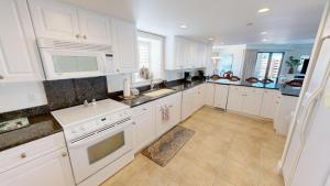 a white kitchen with white cabinets and appliances at Inlet Reef 609 in Destin