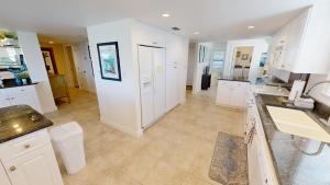 a kitchen with white cabinets and a tile floor at Inlet Reef 609 in Destin