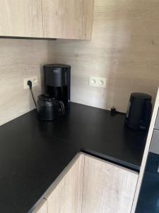 a black counter top with a coffee maker on it at Villa Angelina in De Panne